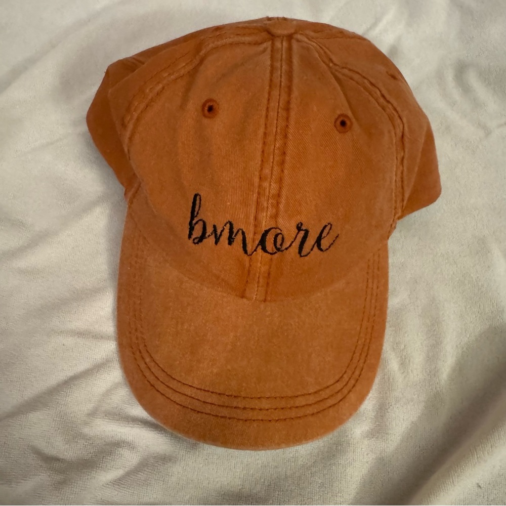 Orange Baseball Hat with Word ‘bmore’ Embroidered in front.